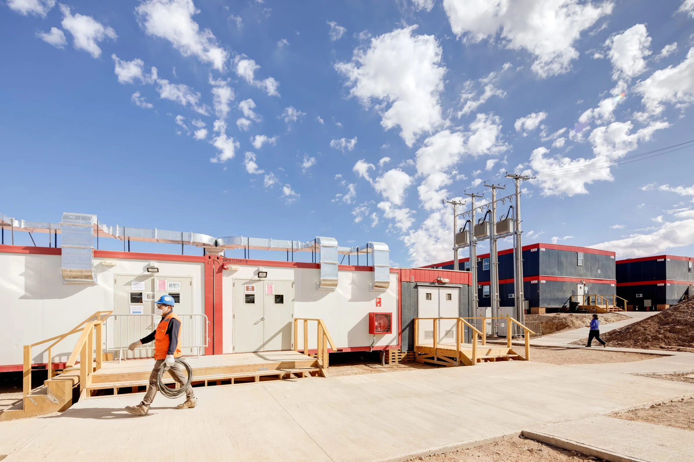 Campamento modular de Tecnofast en una faena minera, con un trabajador caminando frente a los módulos